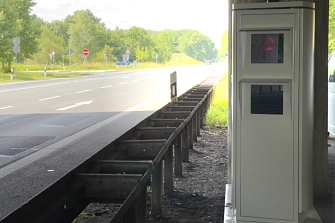 Blick auf einen stationären Blitzer unter einer Brücke, im Hintergrund eine mehrspurige Straße mit Verkehrsschildern und Bäumen.&nbsp;&copy;&nbsp;Landkreis Helmstedt