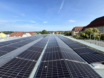 Photovoltaikanlage auf einem Flachdach mit Blick auf eine Kleinstadt unter blauem Himmel.&nbsp;&copy;&nbsp;Landkreis Helmstedt
