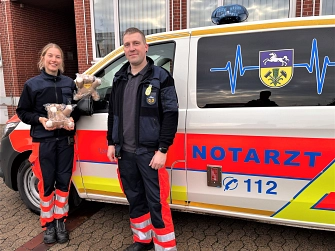 Katharina Schulze und Volker Fricke stehen mit zwei Trösteteddys vor einem Notarztwagen.&nbsp;&copy;&nbsp;Landkreis Helmstedt