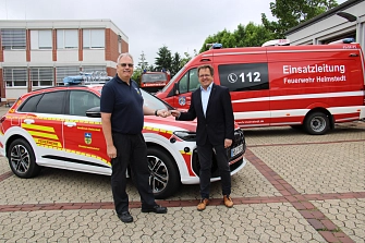 Zwei Männer schütteln sich vor einem Feuerwehrfahrzeug und einem Einsatzleitungs-Transporter der Feuerwehr Helmstedt die Hand.&nbsp;&copy;&nbsp;Landkreis Helmstedt